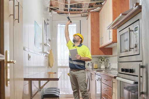 A team member of Kelmann Restoration is inspecting a damaged home for restoration in Sheboygan, WI