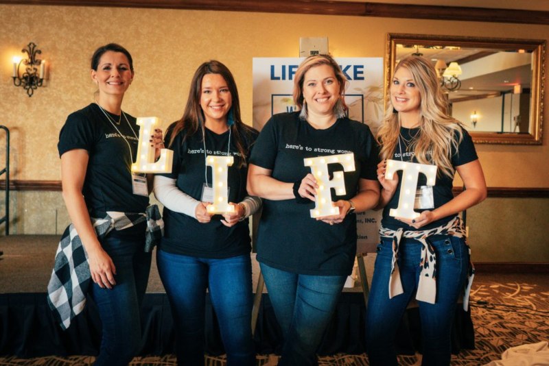 Four Attendees Holding Illuminated Letters Spelling 'LIFT' at a Community Summit in Wauwatosa, WI