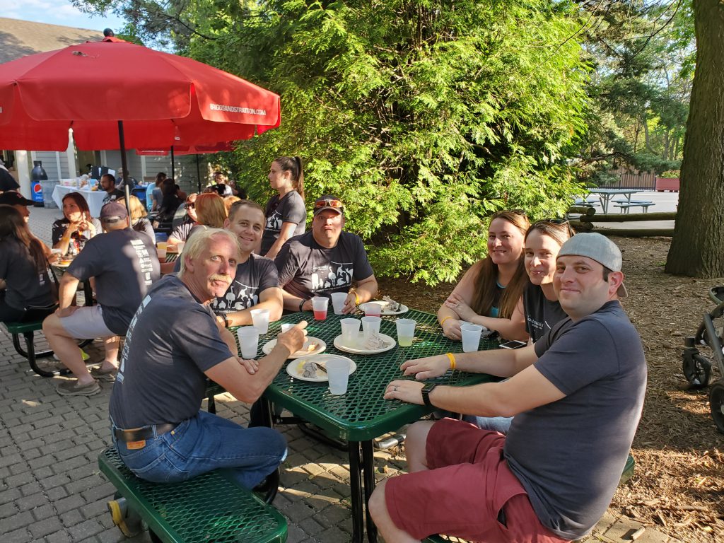 group of people sitting at green picnic table